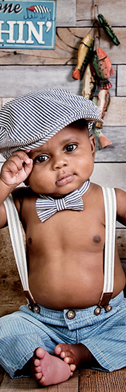 Young boy dressed in suspenders and a newsboy cap, photographed by St. Louis wedding photographer Tracey Bartmann-Leek.